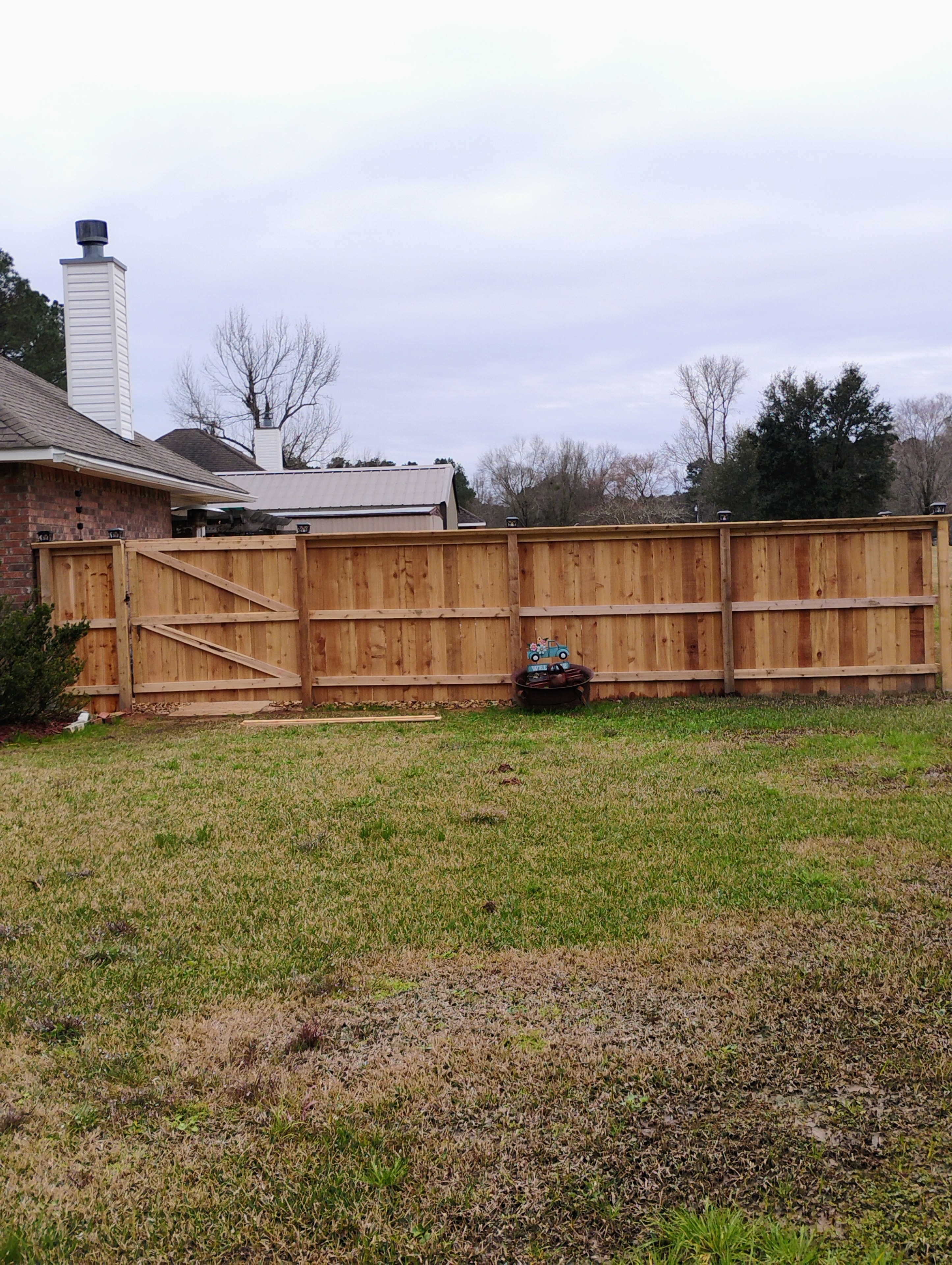 Cedar privacy fence with gate along brick home in Alexandria, LA – Fortified Fence and Weld