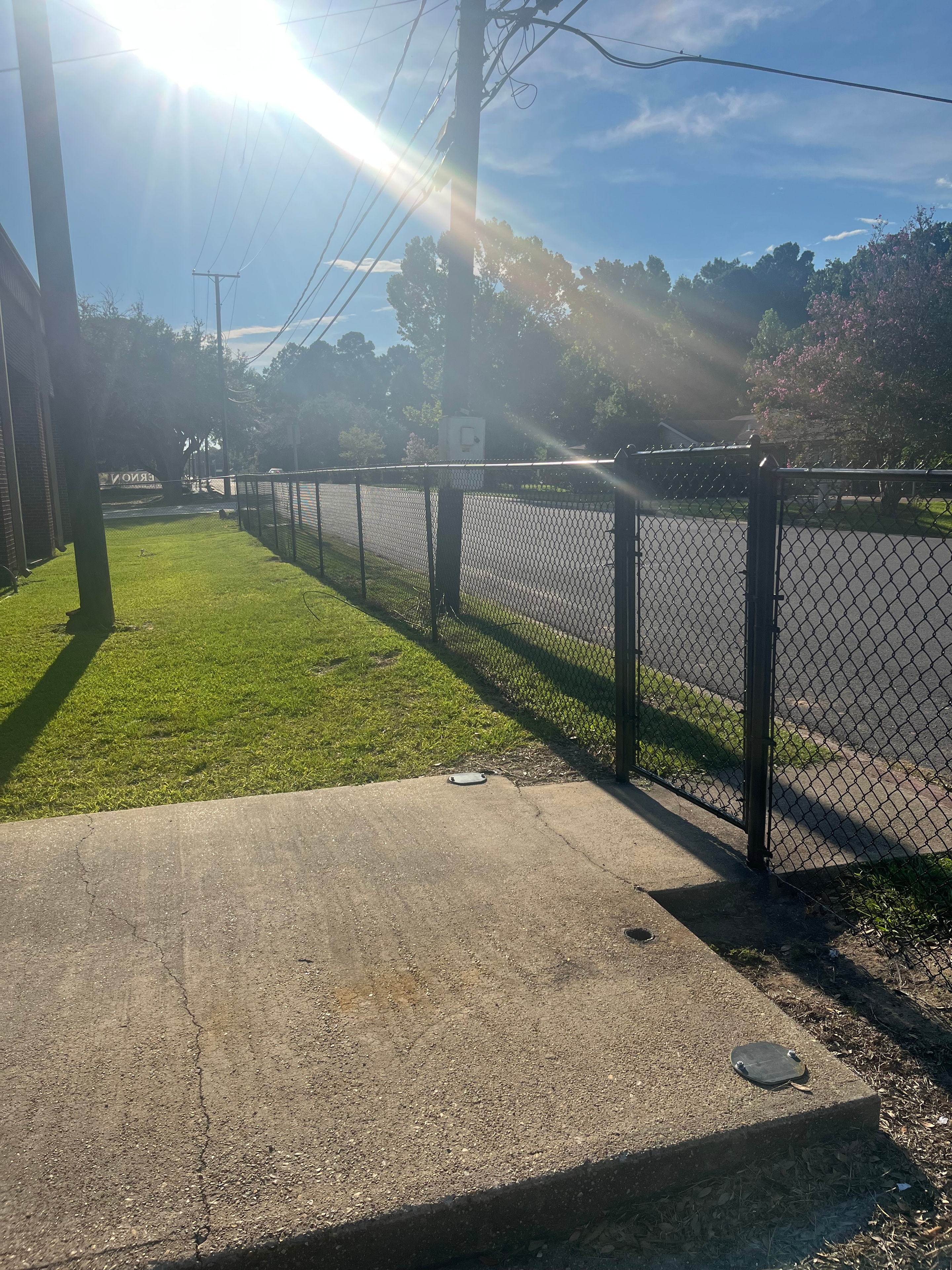 Black chain link fence with expanded metal gate panel on concrete pad — Fortified Fence and Weld, Alexandria LA