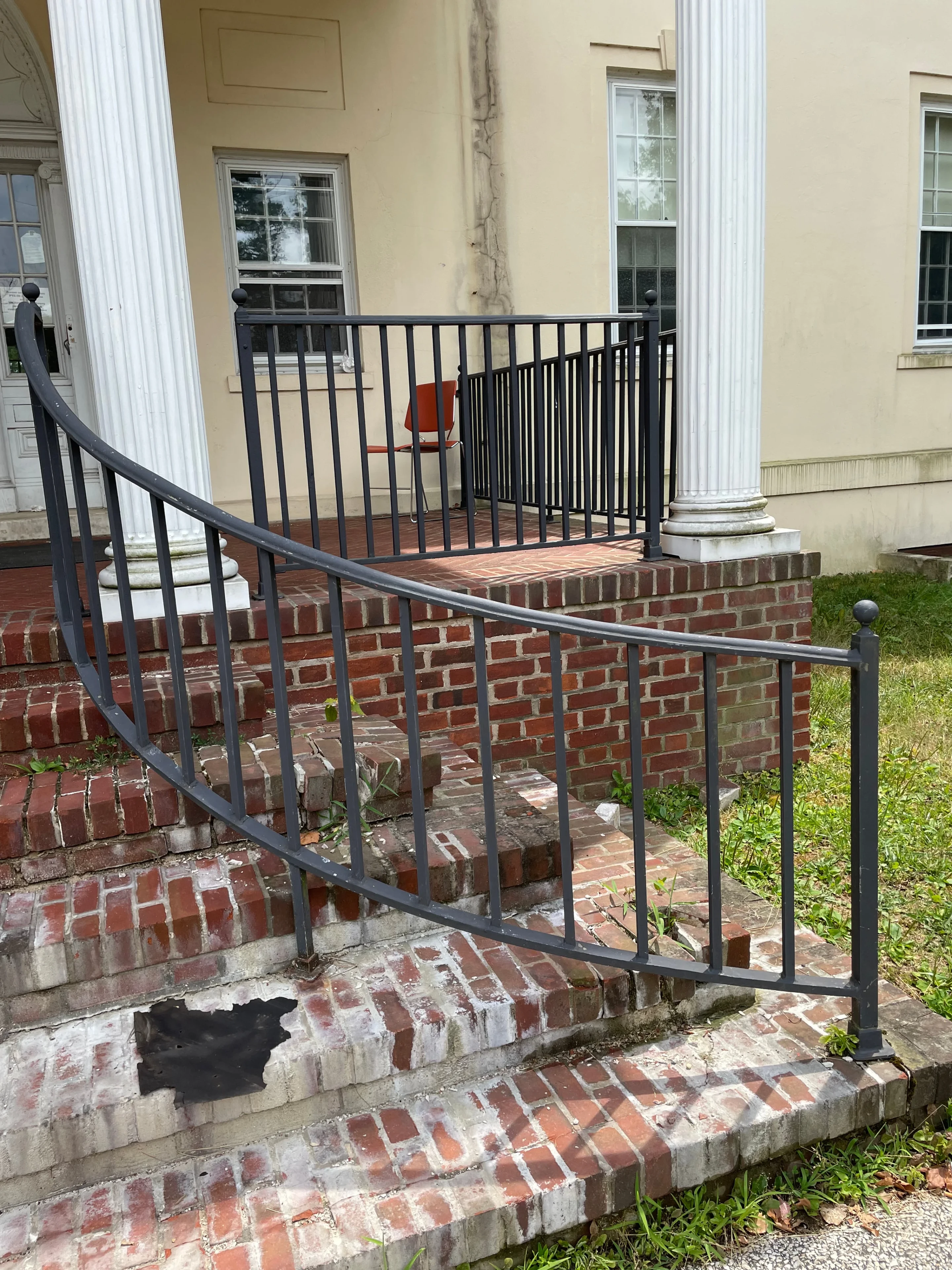 Custom black curved iron handrails and railing on brick steps at columned historic building — Fortified Fence and Weld, Alexandria LA