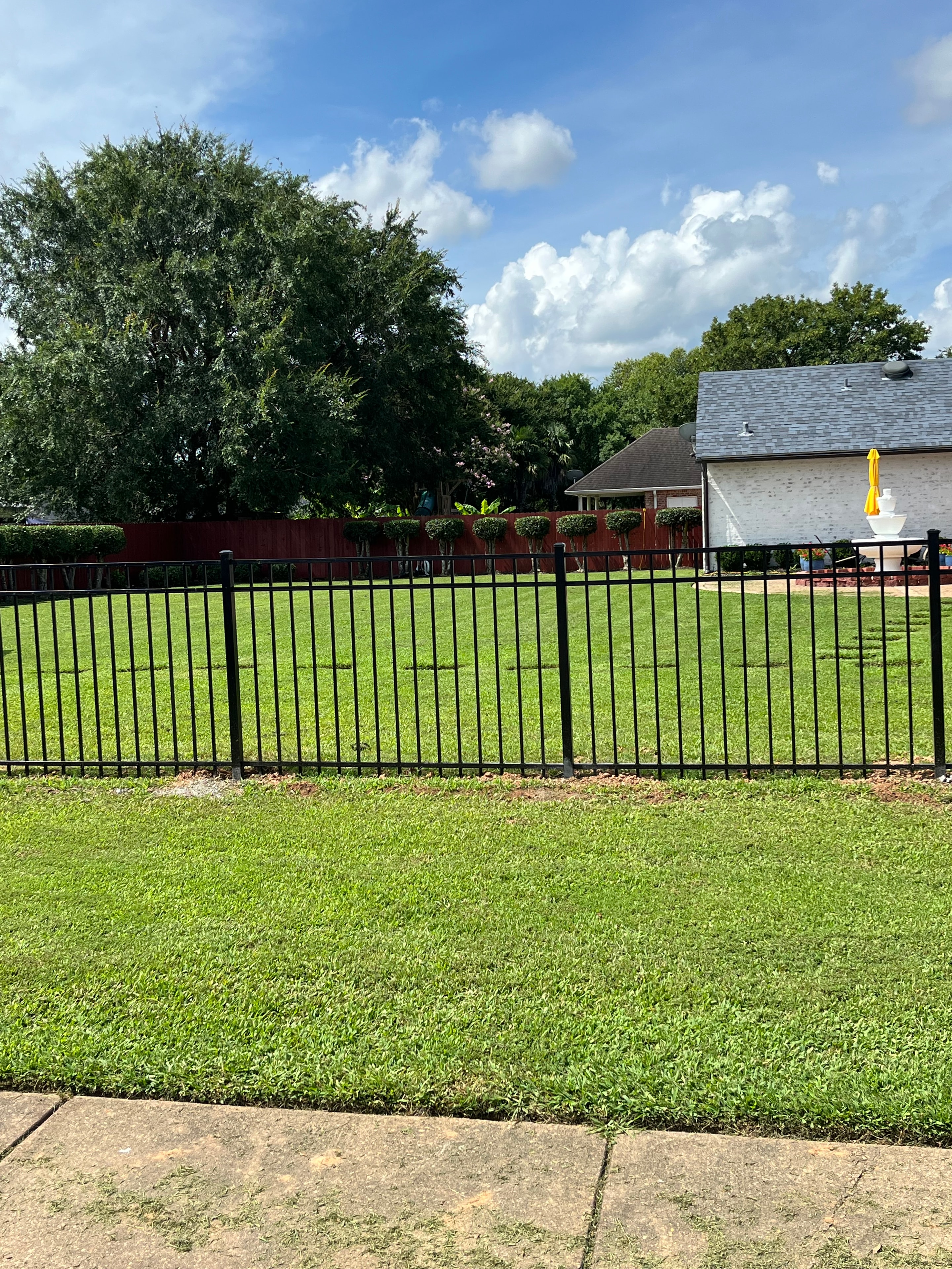 Black ornamental iron fence along brick home yard in Alexandria, LA – Fortified Fence and Weld