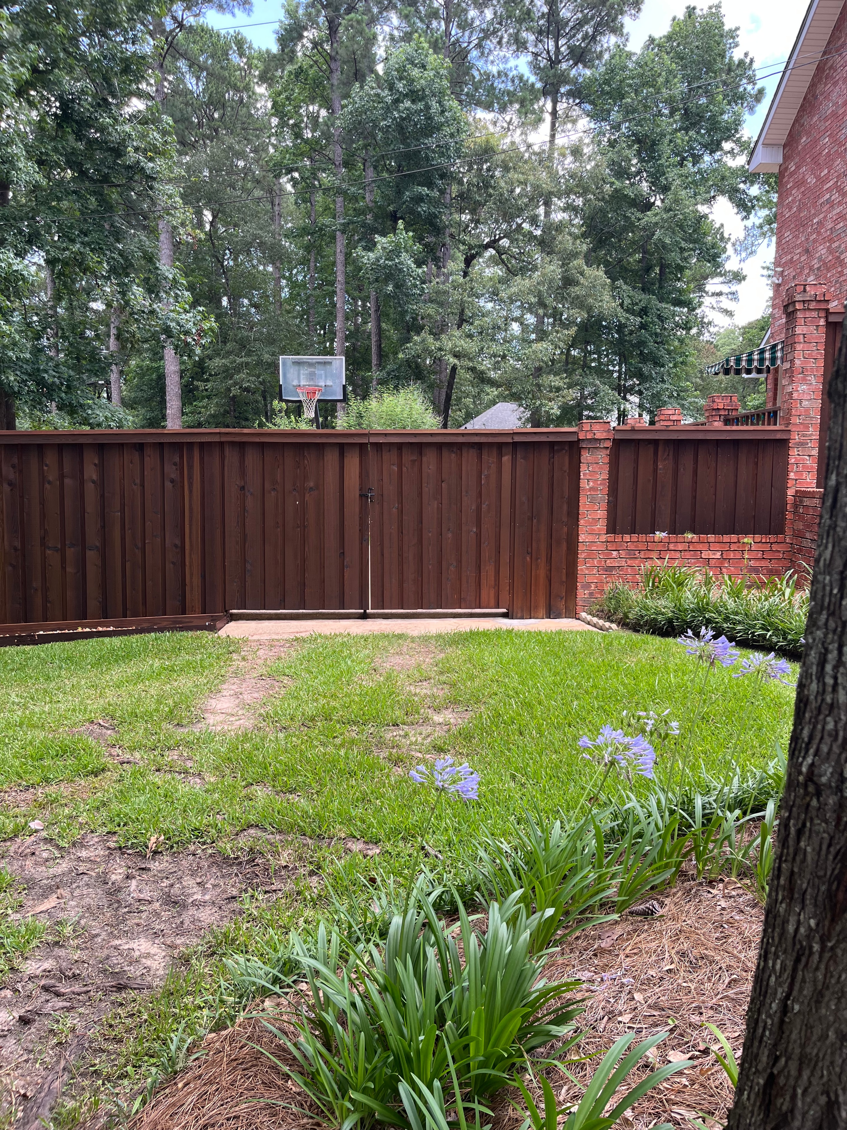 Cedar wood privacy fence beside brick home with garden landscaping in Alexandria, LA – Fortified Fence and Weld