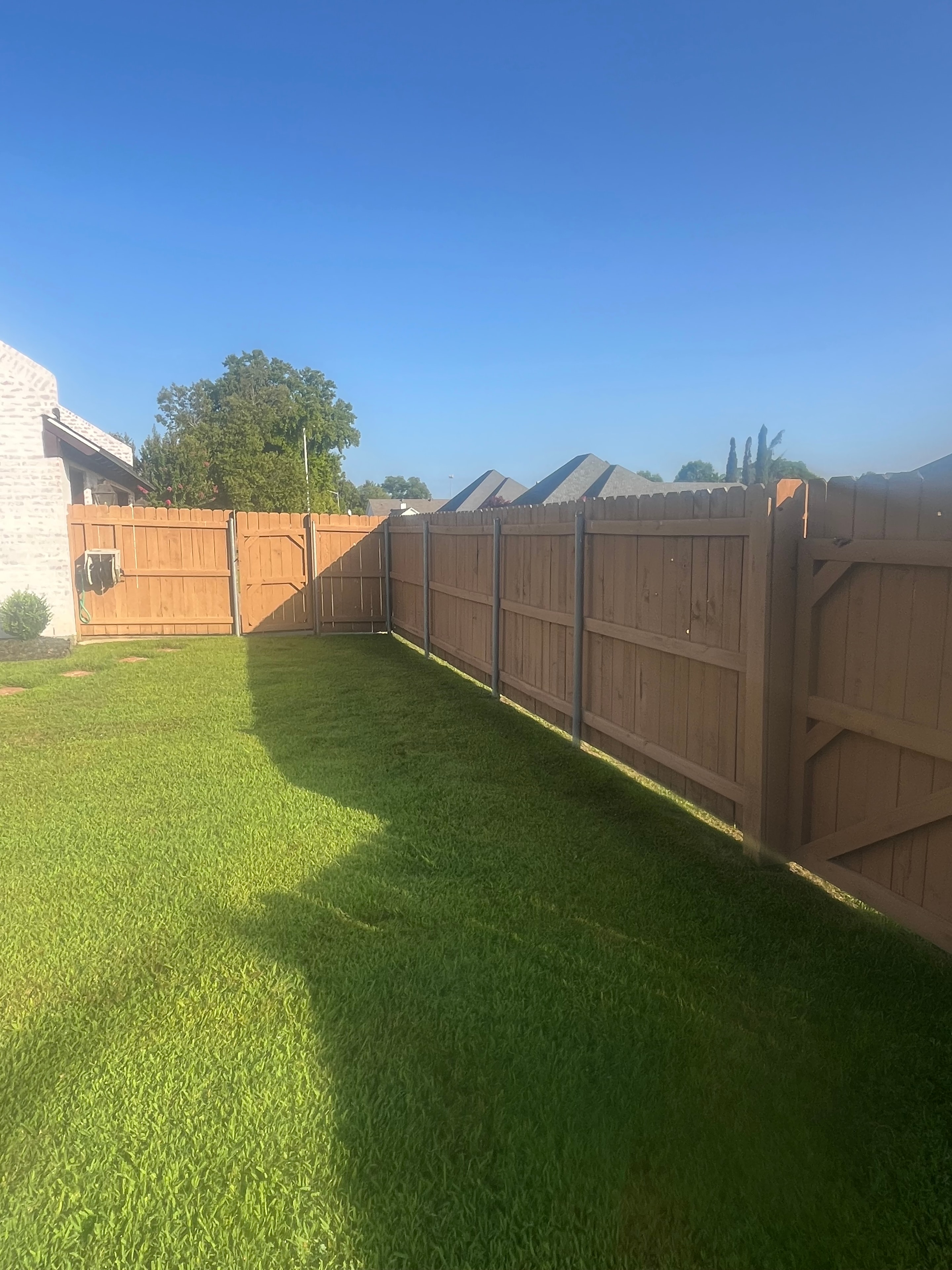 Cedar wood privacy fence with covered porch and green lawn in Central Louisiana – Fortified Fence and Weld